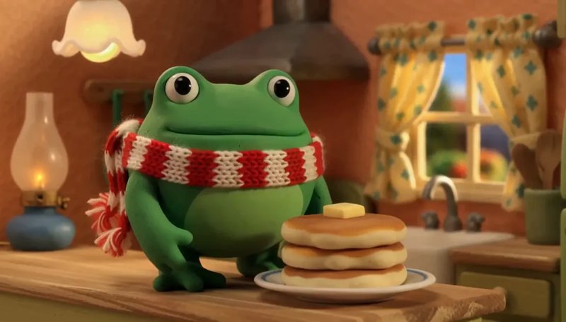 Stop-motion still: a claymation frog with pancakes in a tiny kitchen